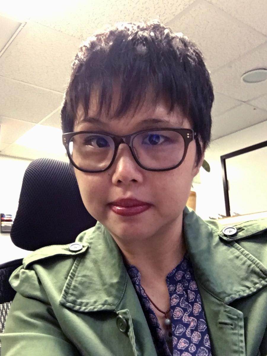 Person with short hair wearing thick-rimmed glasses.