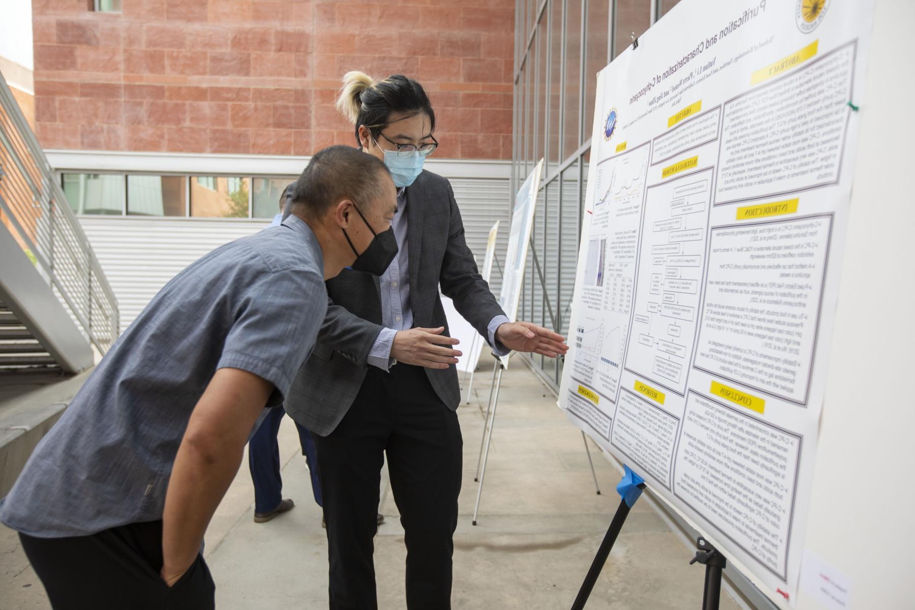 Student displaying research project to prospective student