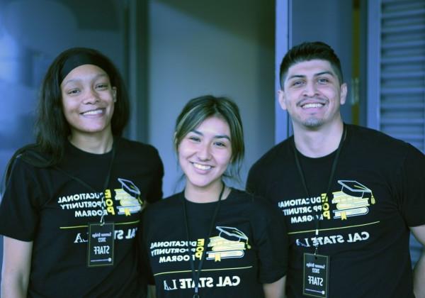 三个穿着教育机会计划t恤的学生微笑着