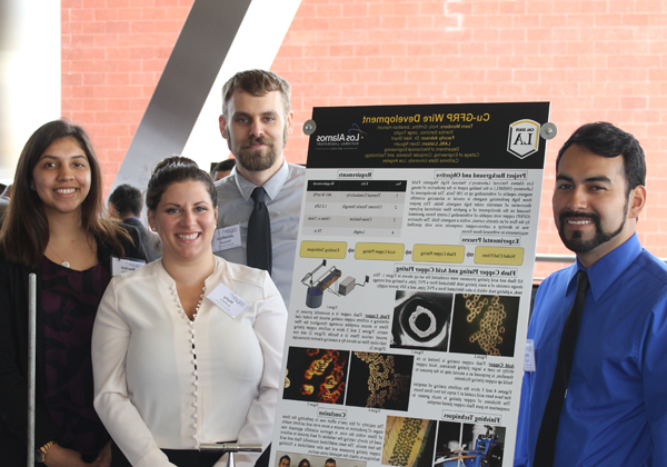 capstone student team stand with project poster at expo