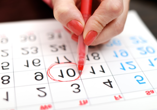 Hand circling a date on a calendar