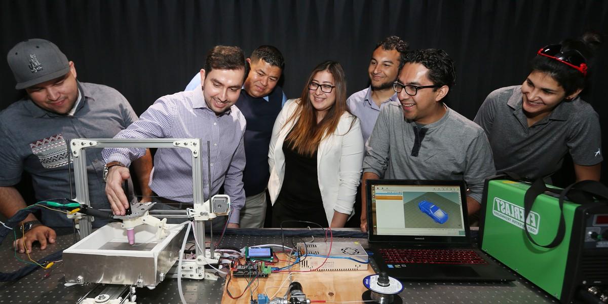 faculty and students work with 3d printer in lab