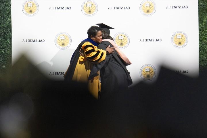 President Eanes gives a hug to a graduate at Commencement 2024.