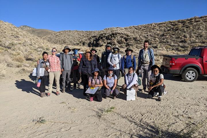 Group of 14 students standing in the desert.
