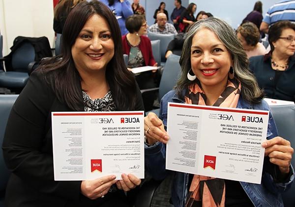 two faculty members showing their certificates after participating in CETL Workshop