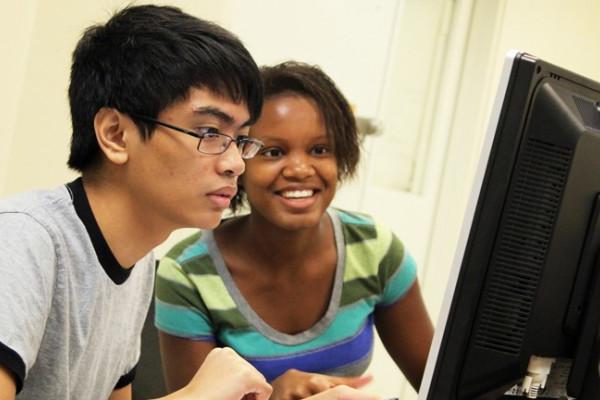 两个荣誉学院的学生聚精会神地面对着电脑屏幕. 