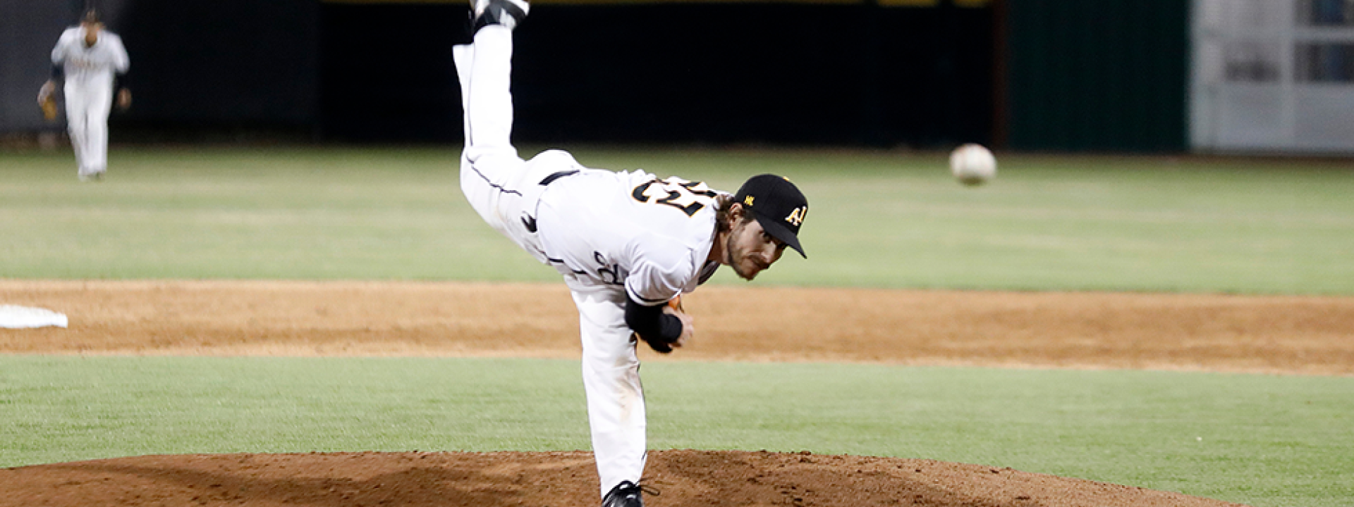 Image of a Cal State LA pitcher on the mound, mid-throw. 