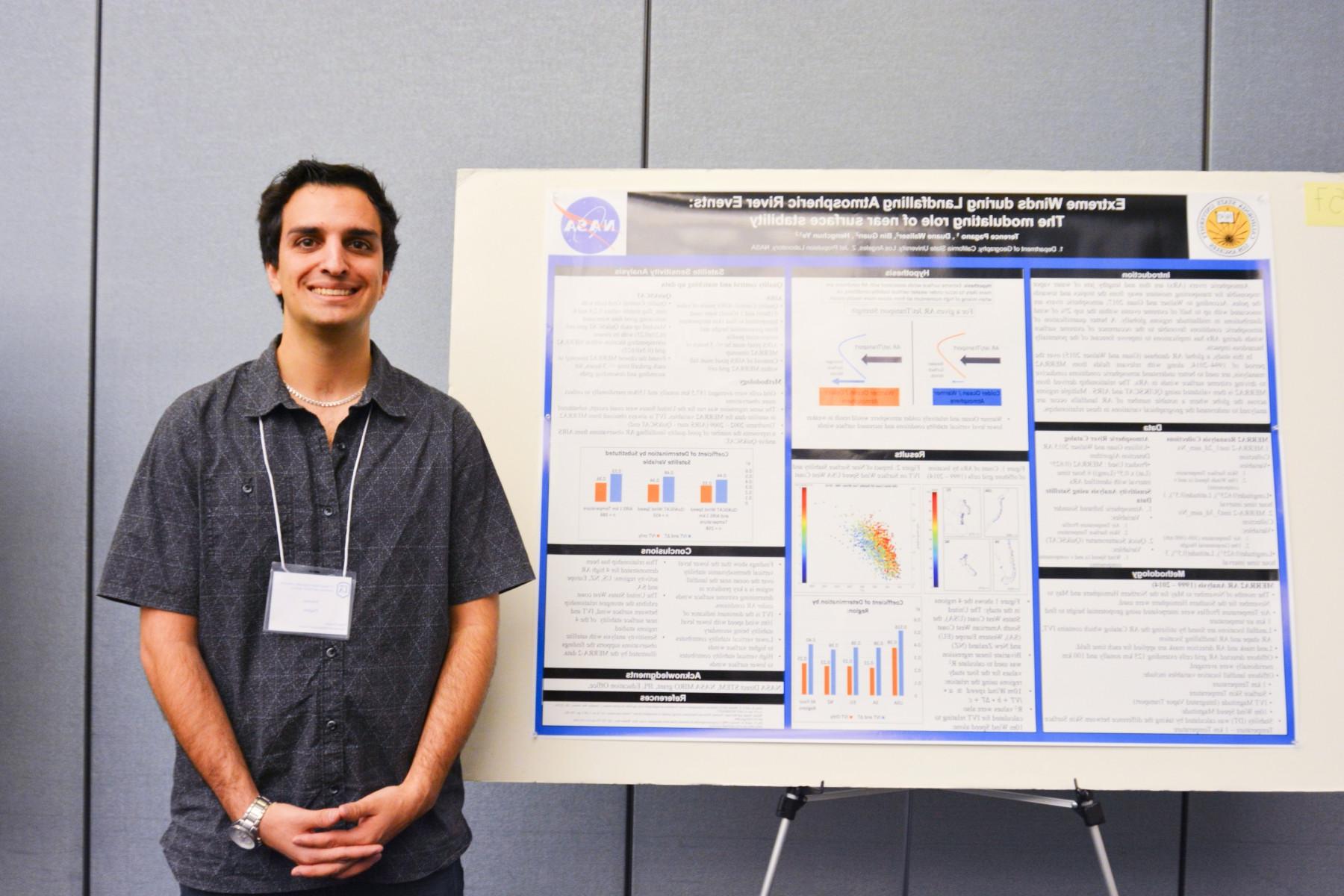 student in front of his poster presentation
