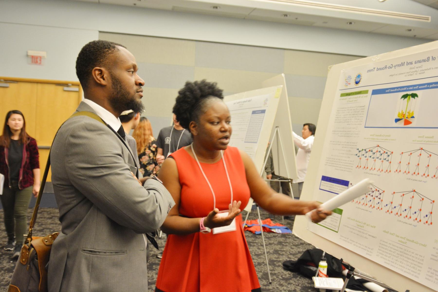 student discussing her poster presentation with attendee